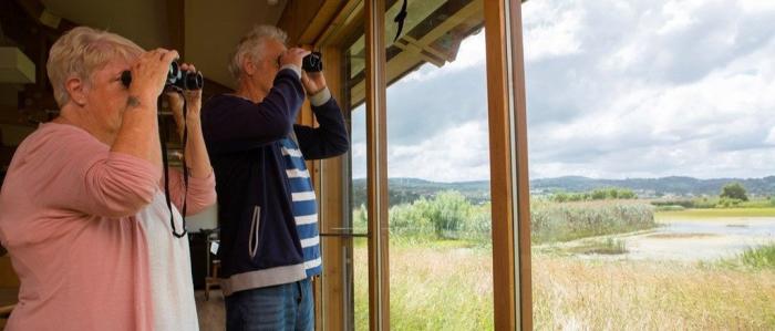 Two people birdwatching from the Bowling Green Marsh hide