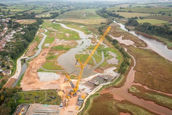 An aerial photo of a crane lifting the footbridge into place, Lower Otter Restoration Project.