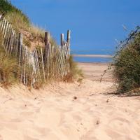 Gap in fence on a sandy beach